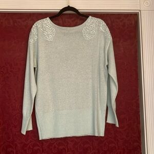 pretty light green sweater with floral designs on shoulder